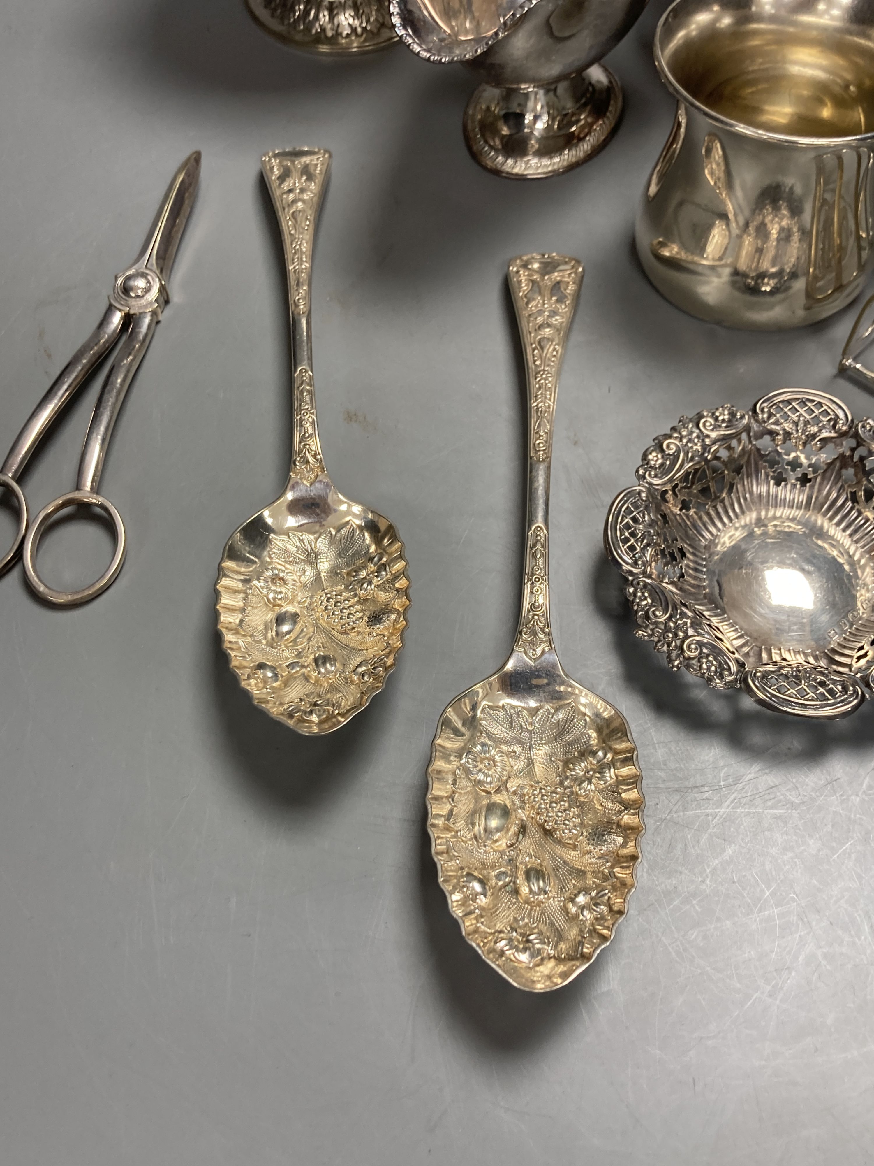 A sterling mug, a silver bonbon dish, a white metal strainer and a group of minor plated items.